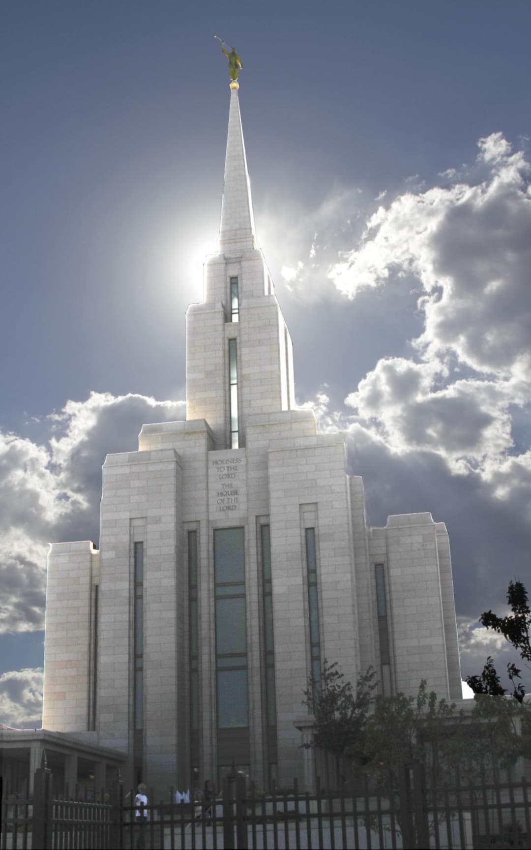 Low-angle view of the temple spire backlit by the sun.
