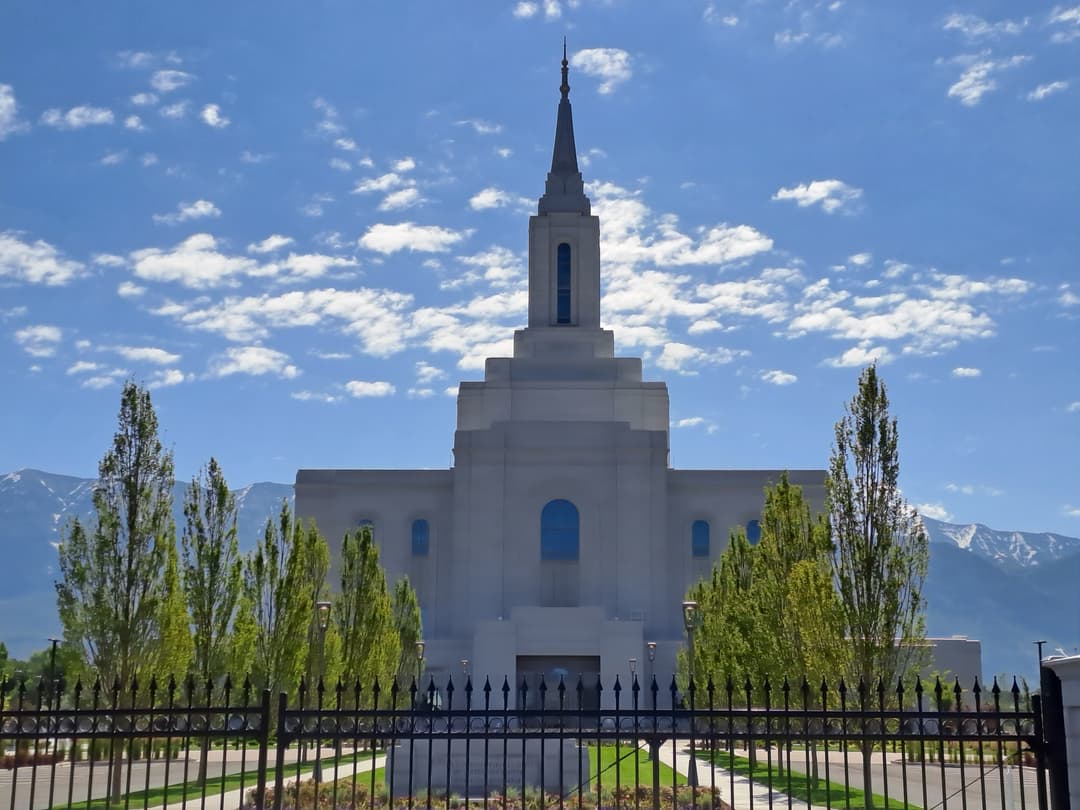 Front exterior view of the Orem Utah Temple behind a wrought iron fence.