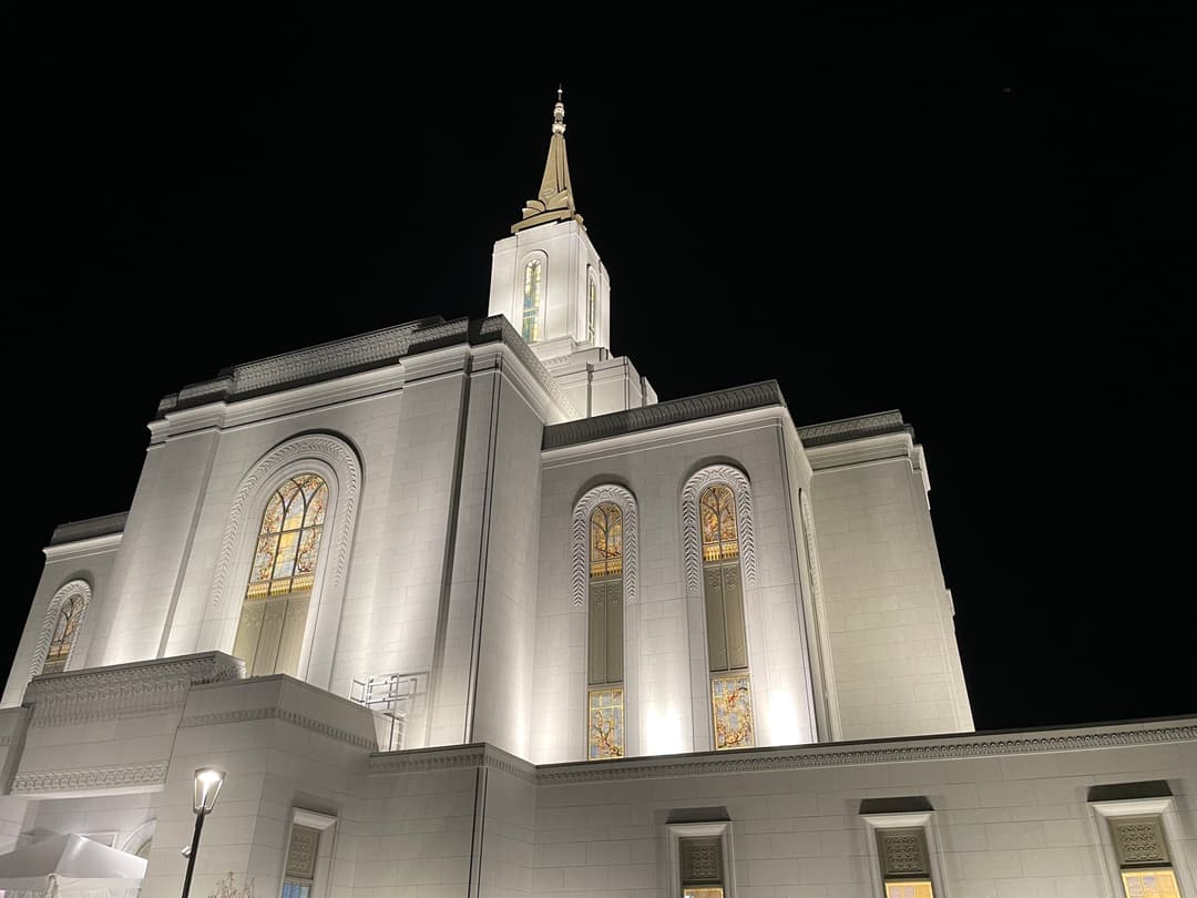Low-angle view of the illuminated Orem Utah Temple facade at night.