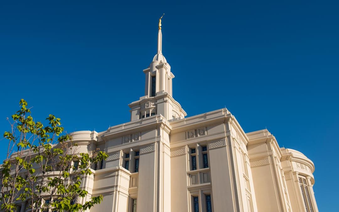 Low-angle view of the central spire and facade against a clear sky.