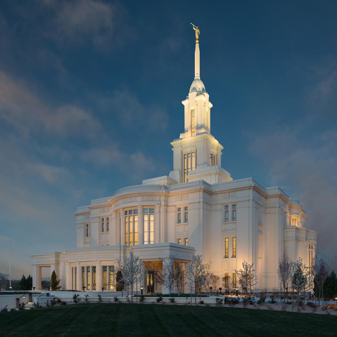 Exterior view of the illuminated Payson Utah Temple at twilight.
