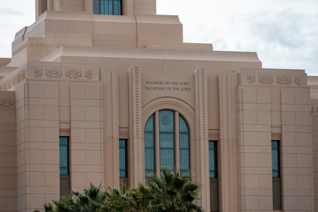 Detail view of the facade inscription and central arched window.