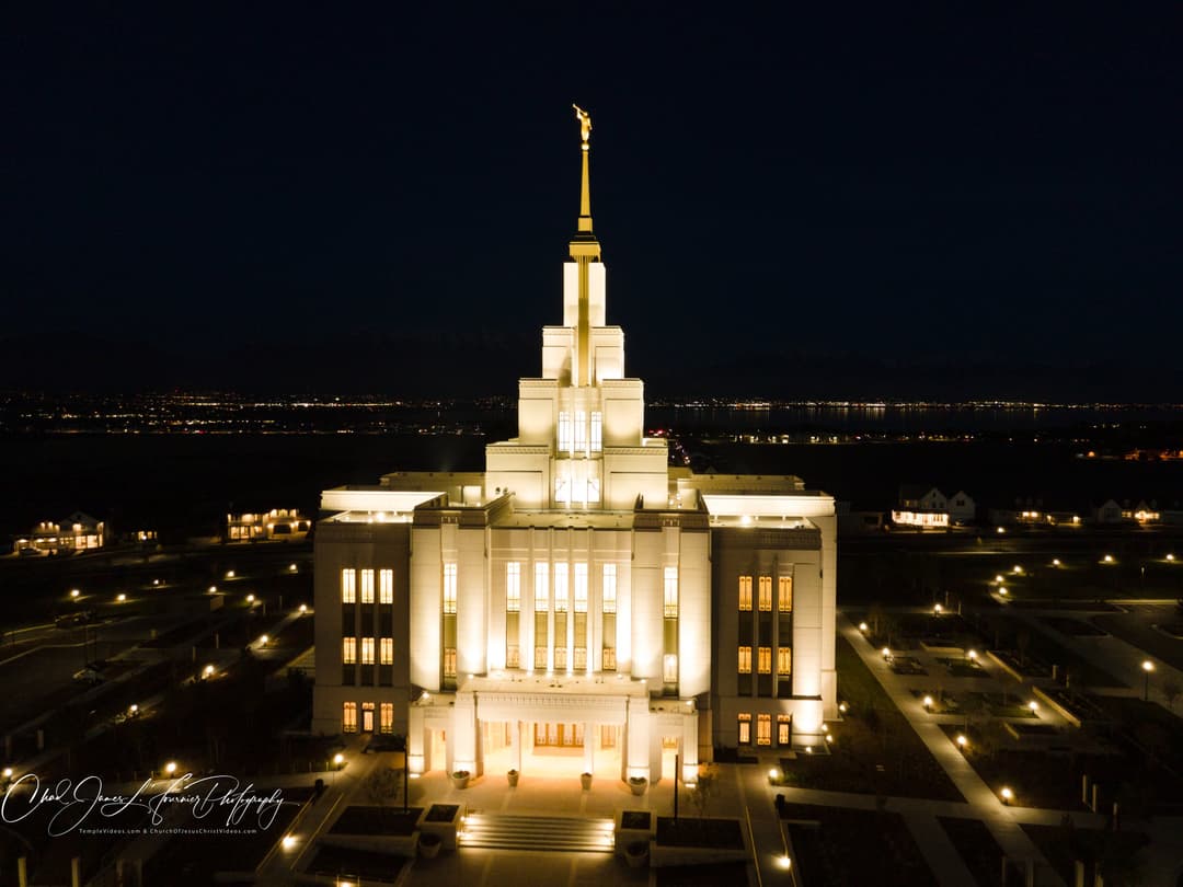 Aerial view of the illuminated Saratoga Springs Utah Temple at night.