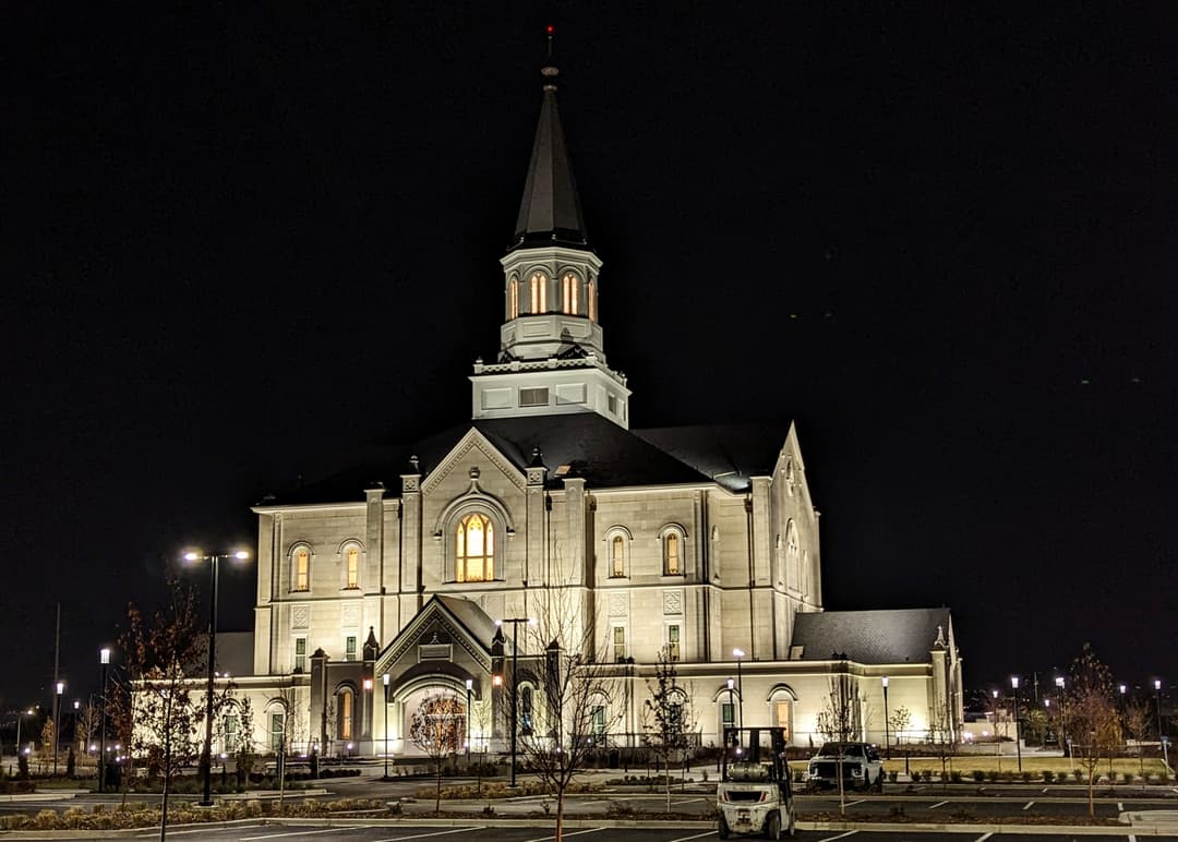 Exterior view of the Taylorsville Utah Temple illuminated at night.