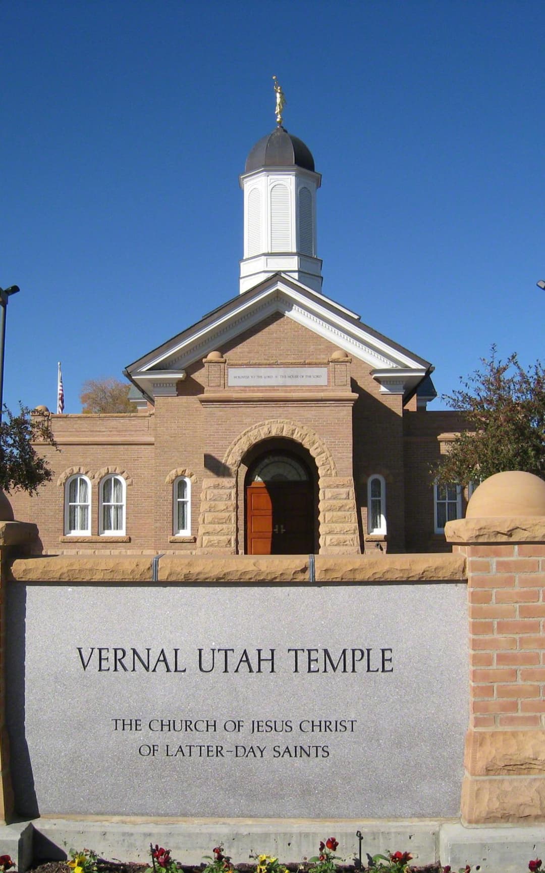 Front entrance sign and main facade of the Vernal Utah Temple in daylight.