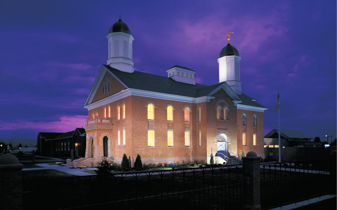 Exterior view of the Vernal Utah Temple illuminated at twilight.