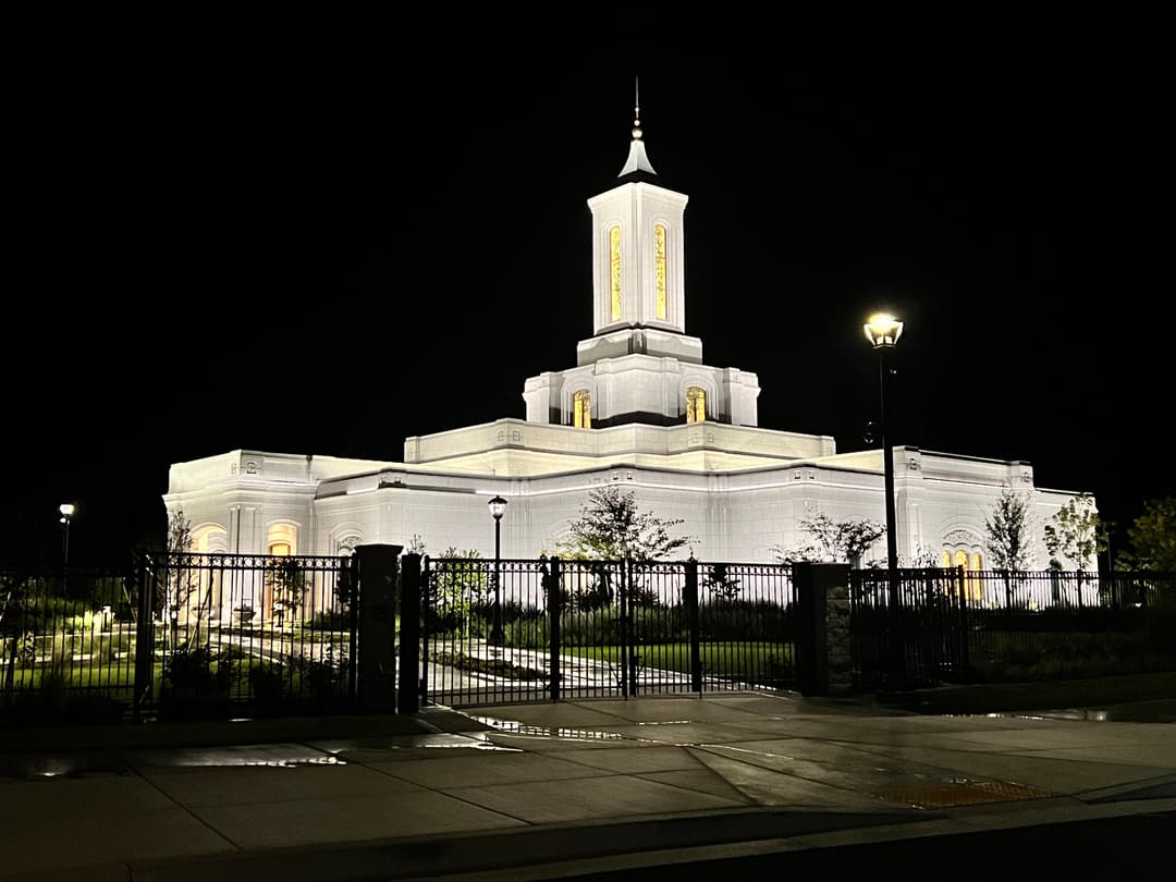 Moses Lake Washington Temple at night, front view with illuminated spire.
