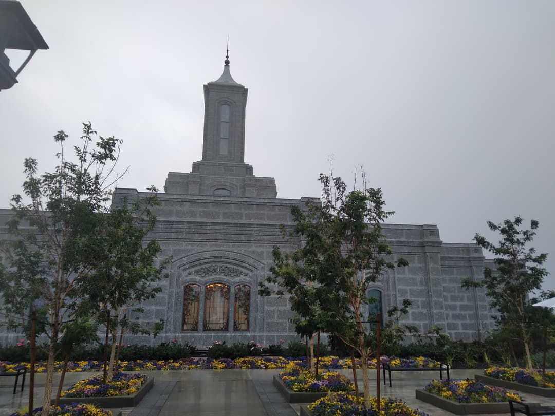 Moses Lake Washington Temple exterior with spire and colorful gardens.