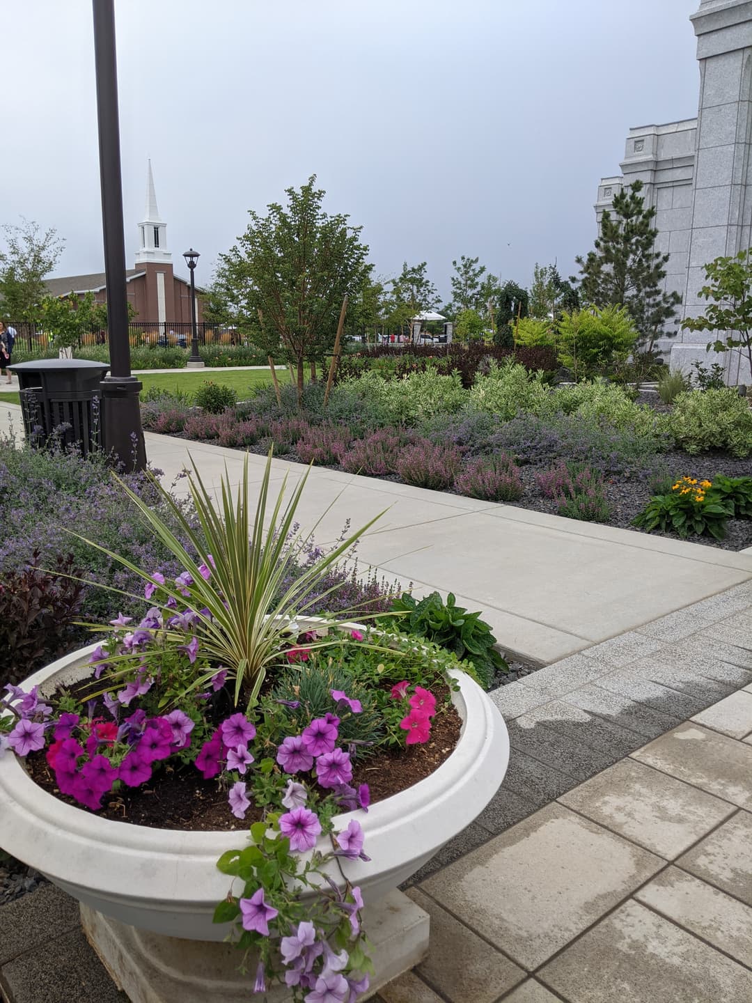 Moses Lake Temple grounds with planter, landscaping, and buildings under overcast sky.