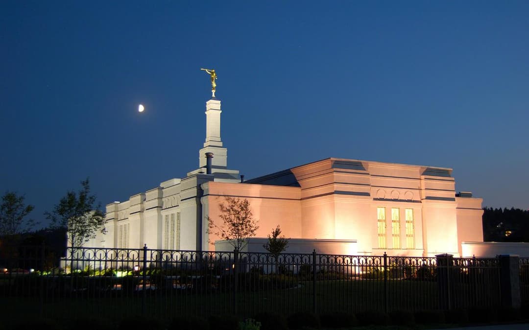 Exterior view of the Spokane Washington Temple illuminated at twilight.