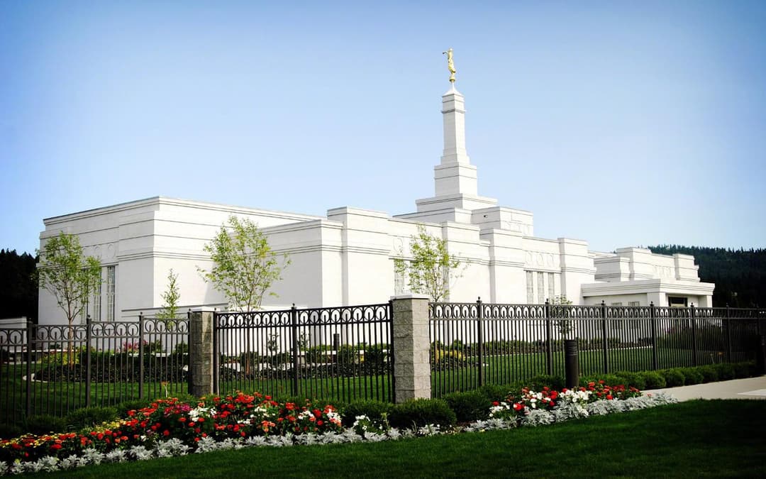 Daytime exterior view of the Spokane Washington Temple behind a flower garden.