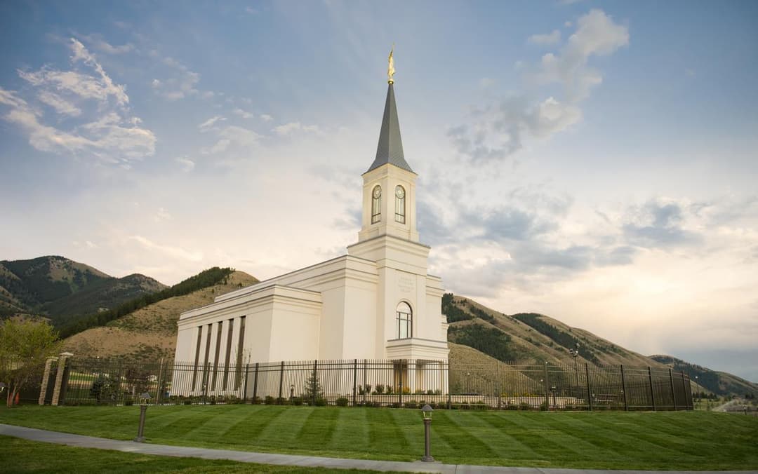 Exterior view of the Star Valley Wyoming Temple against a mountain backdrop.
