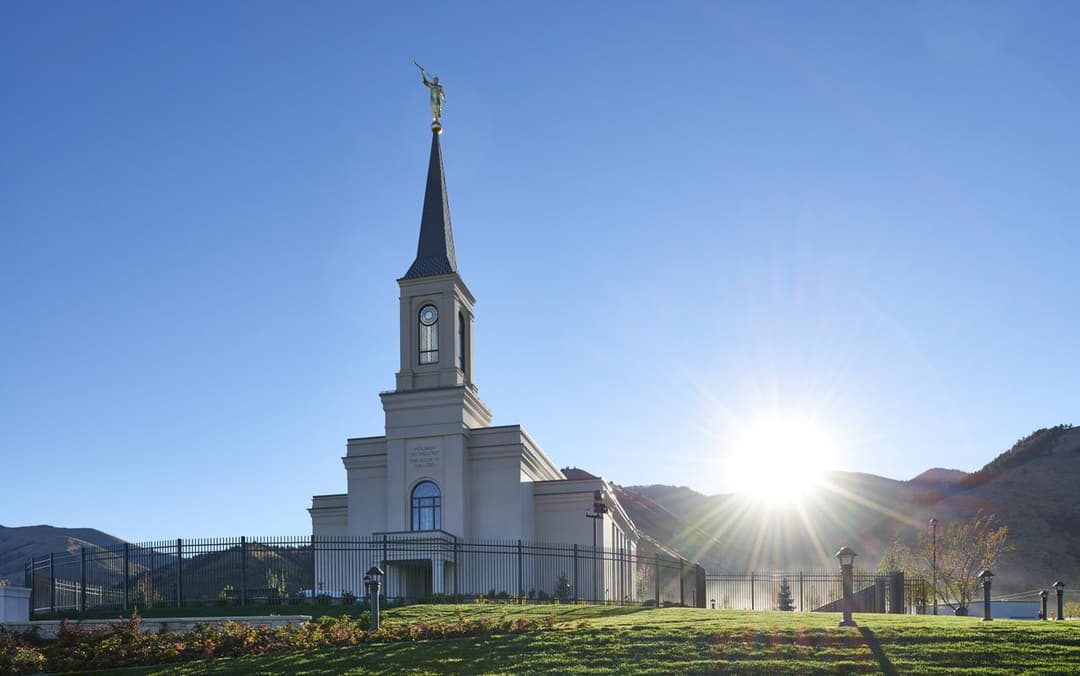 Exterior view of the Star Valley Wyoming Temple with a bright sunburst.