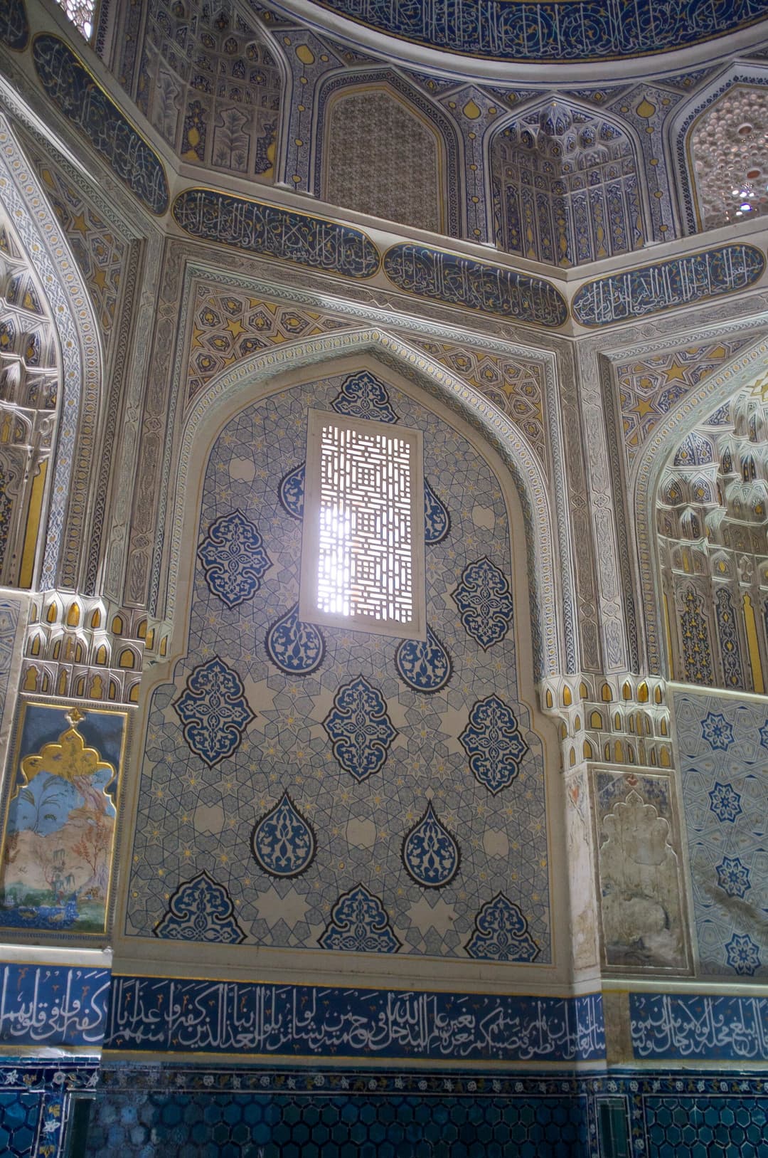 Interior view of a mausoleum with painted murals and latticed window