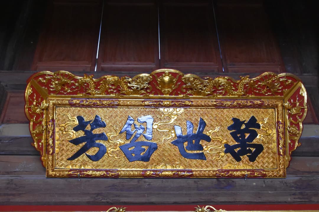 Gilded wooden plaque with traditional Han calligraphy inside Bái Đính Temple.