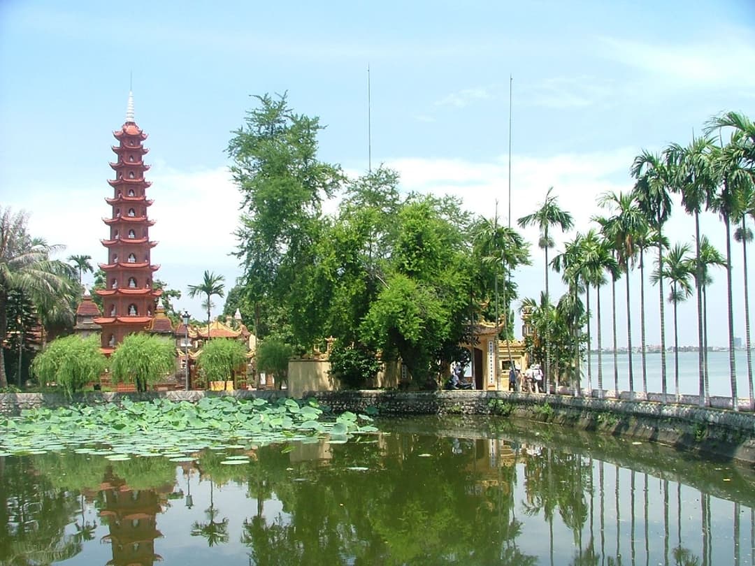 Wide view of the iconic red stupa and lotus pond at Trần Quốc Pagoda.
