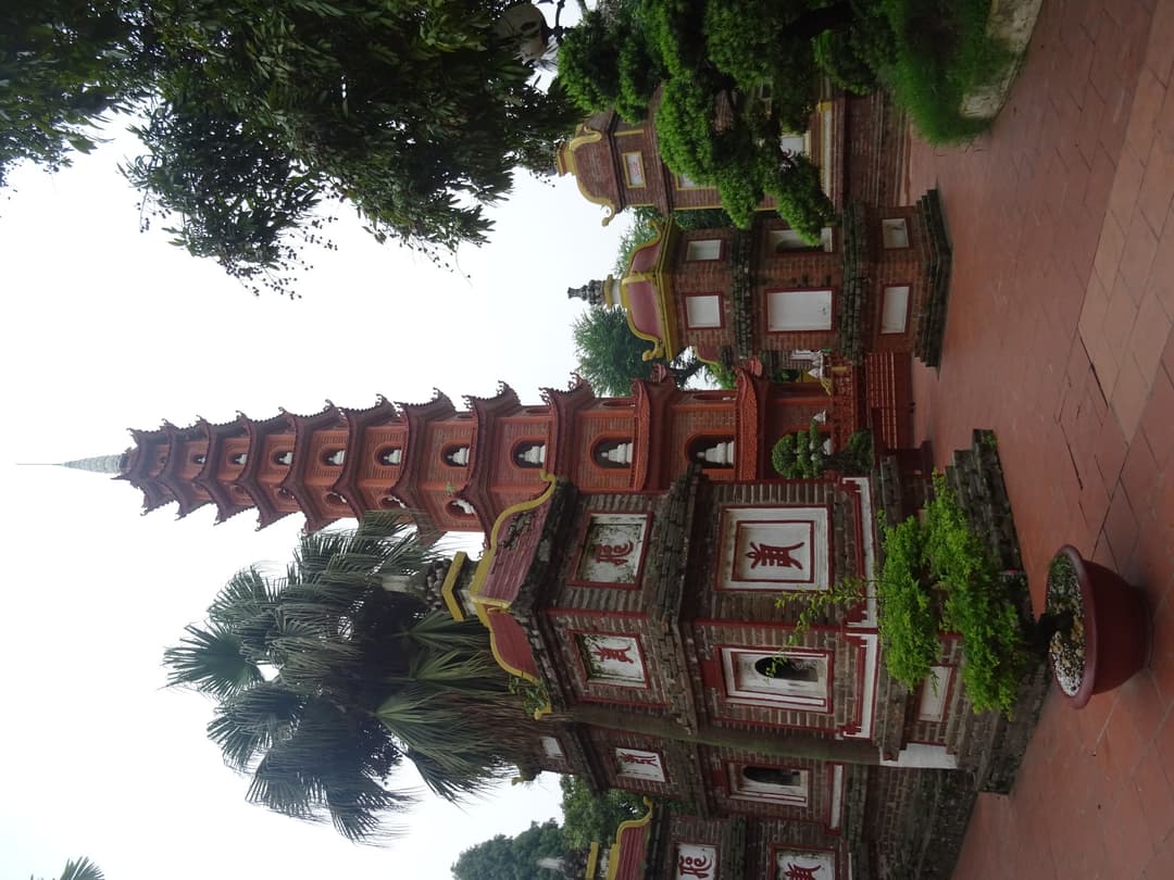 Low-angle view of the tall red stupa and courtyard stupas, Trần Quốc Pagoda.
