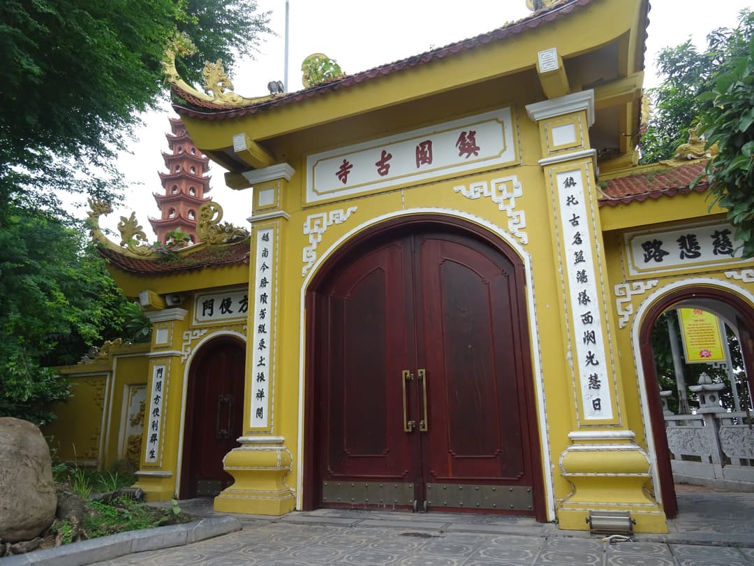 Front entrance gate of Trần Quốc Pagoda with the stupa in the background.