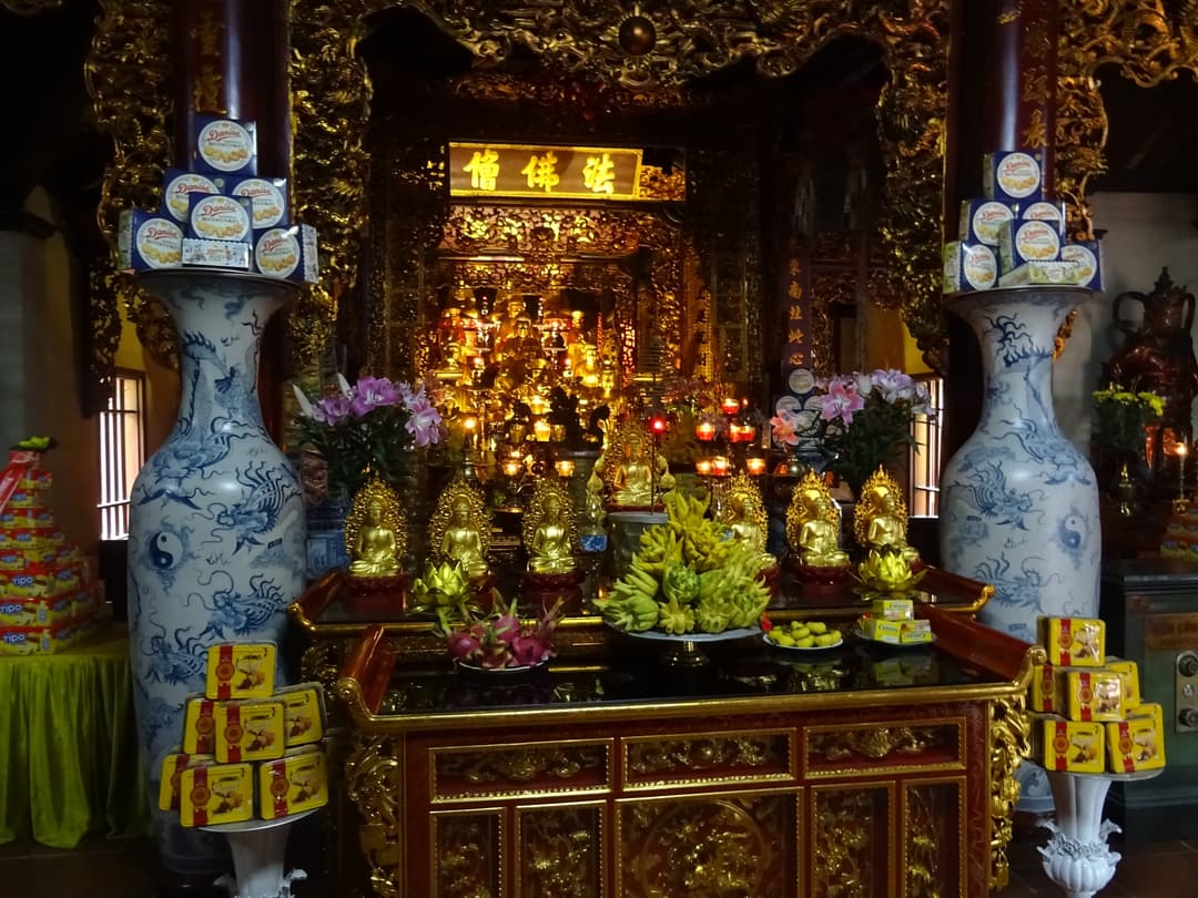 Interior altar with golden Buddha statues at Trần Quốc Pagoda.