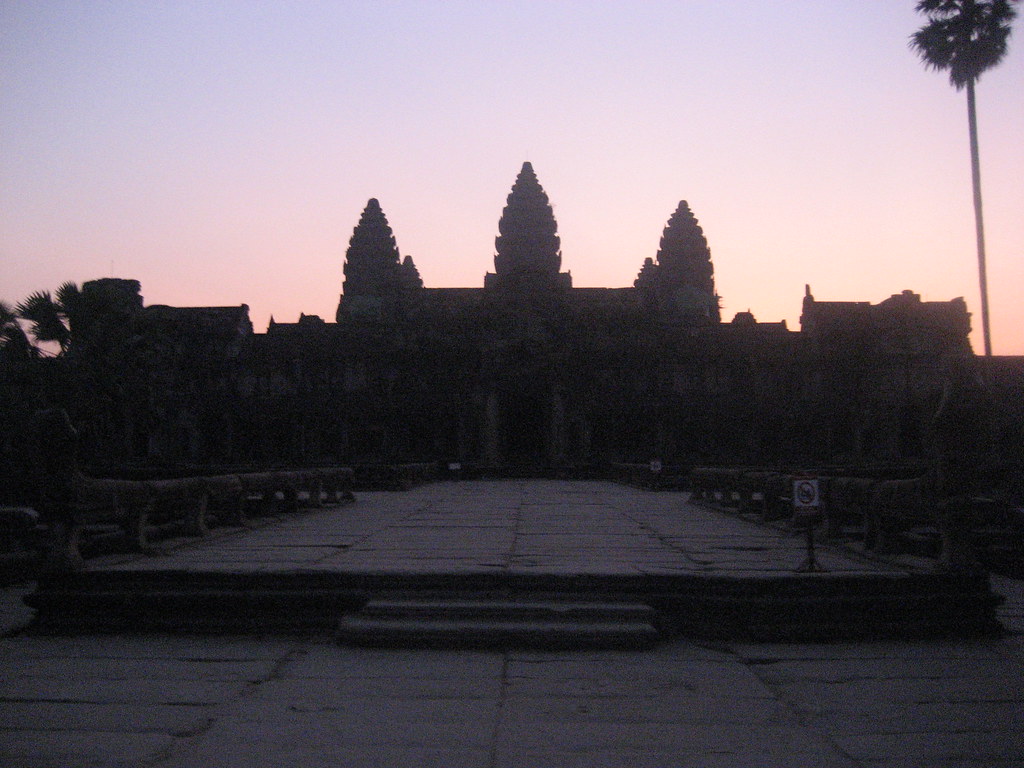 Golden sunrise light illuminating the towers of Angkor Wat.