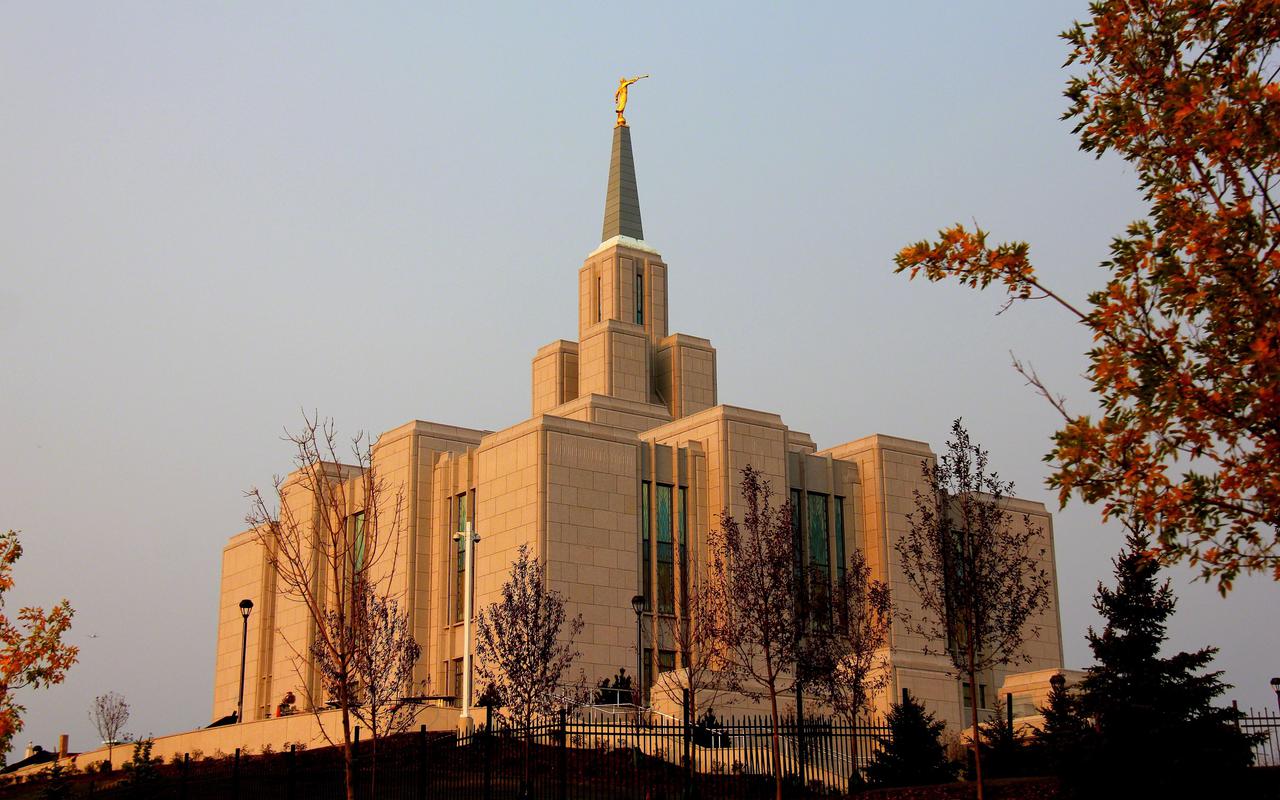 स्वर्ण काल (golden hour) के दौरान Calgary Alberta Temple का निम्न-कोण (low-angle) दृश्य।