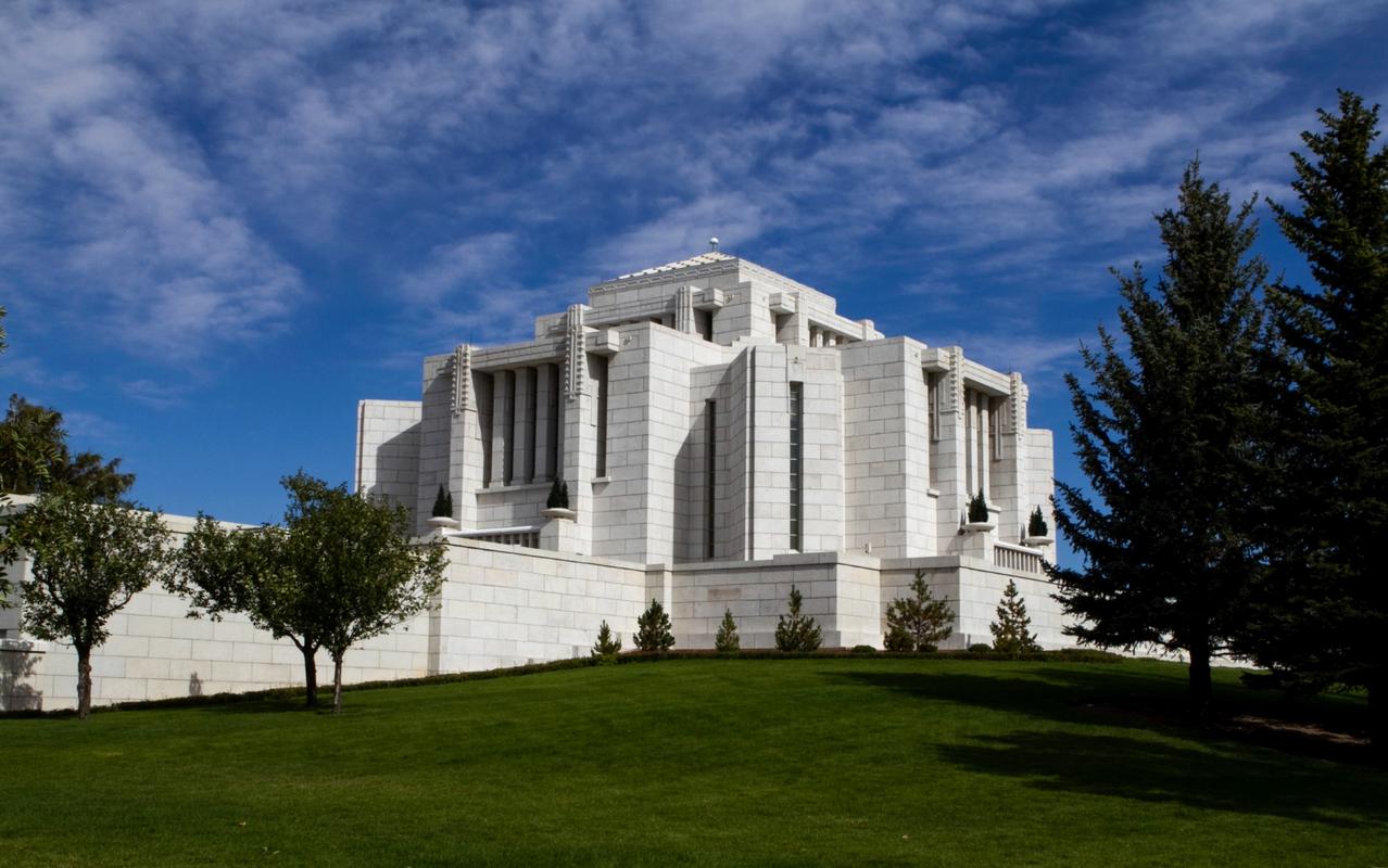 The Cardston Alberta Temple surrounded by lush greenery.