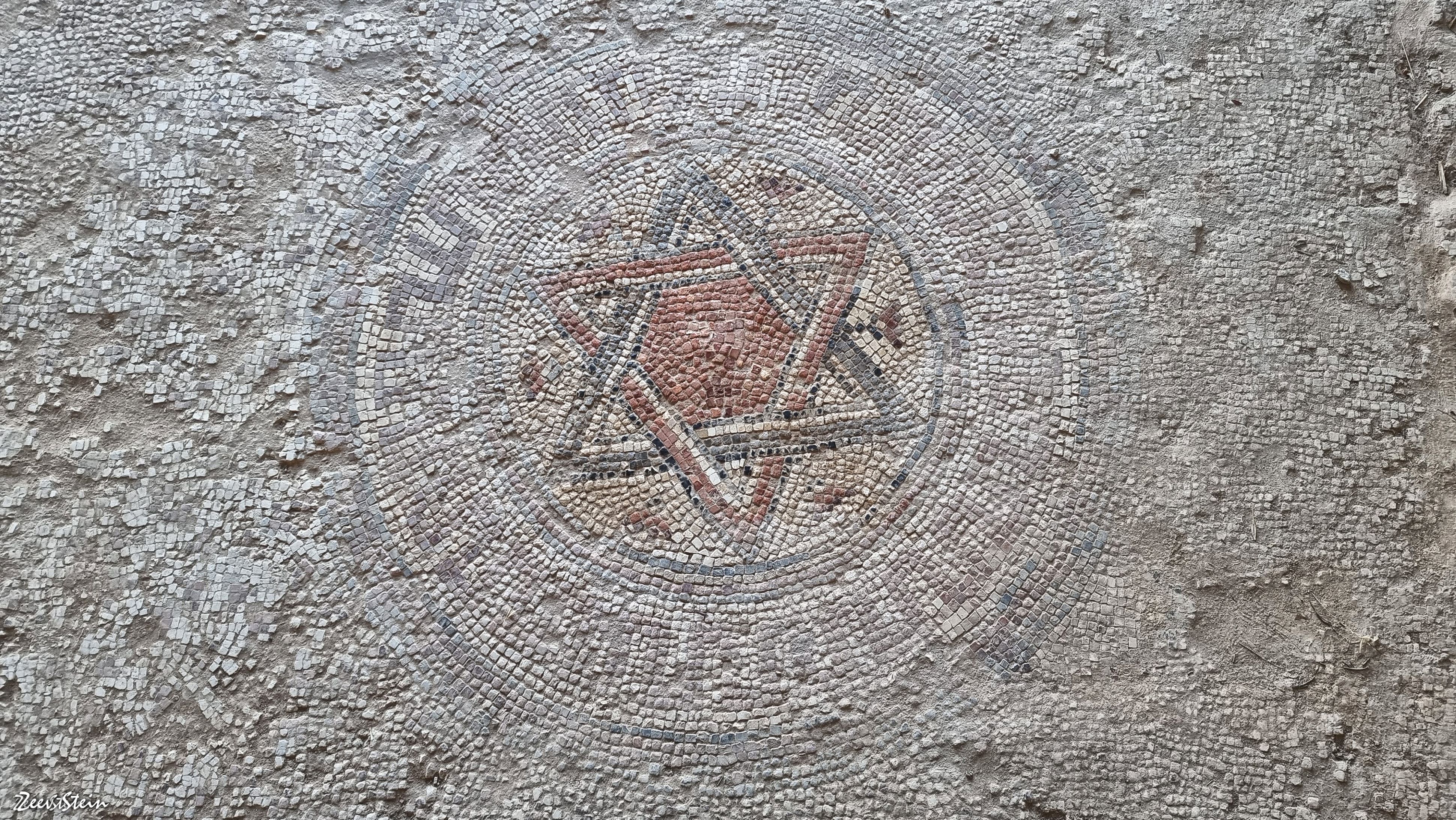 Well-preserved ancient mosaic floor displaying geometric patterns.