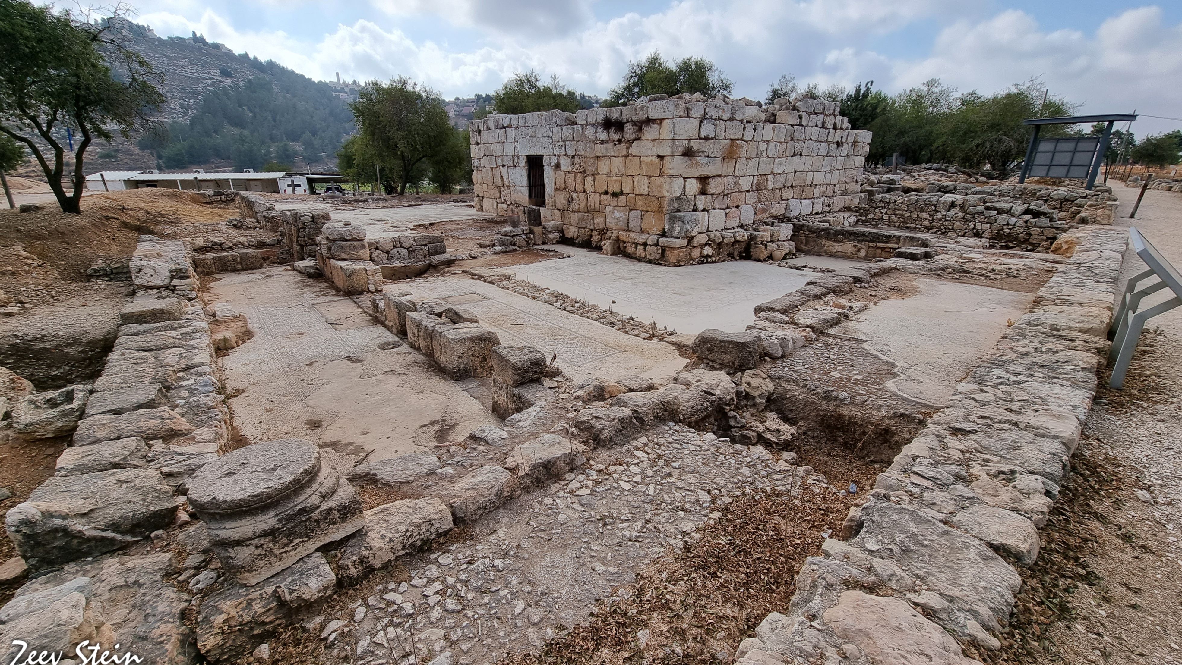 Exposed ruins showing stone foundations and mosaic details.