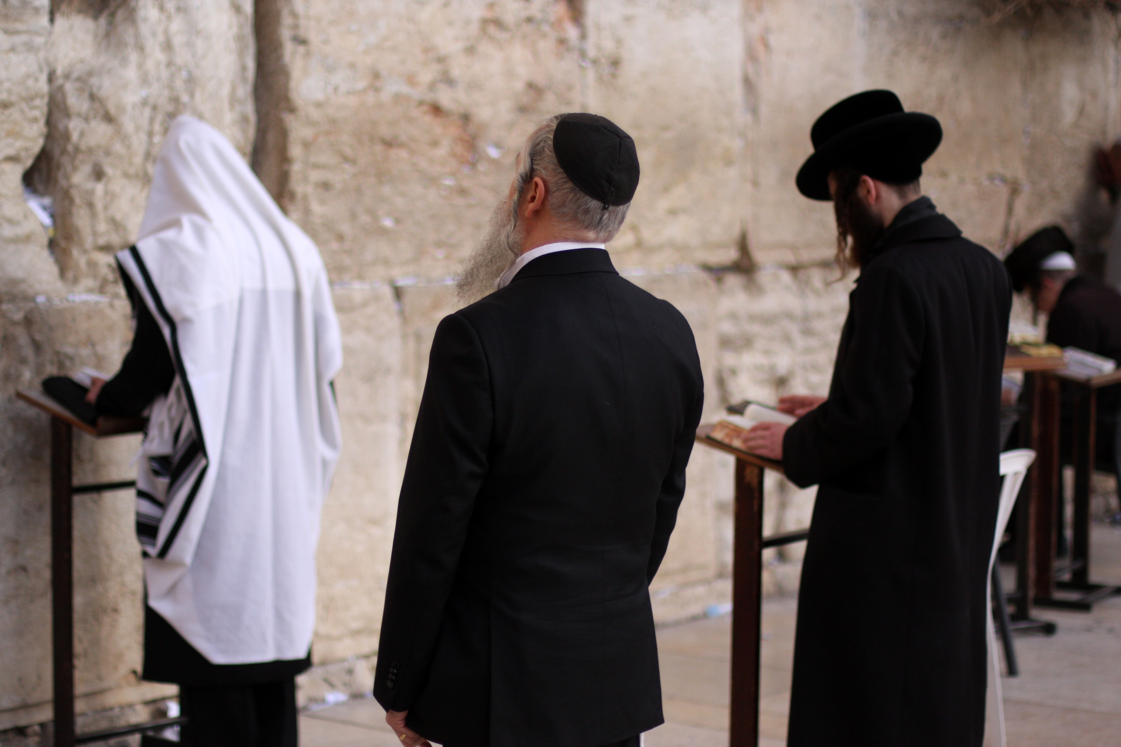 Visitors inserting prayers into the crevices of the Wall.