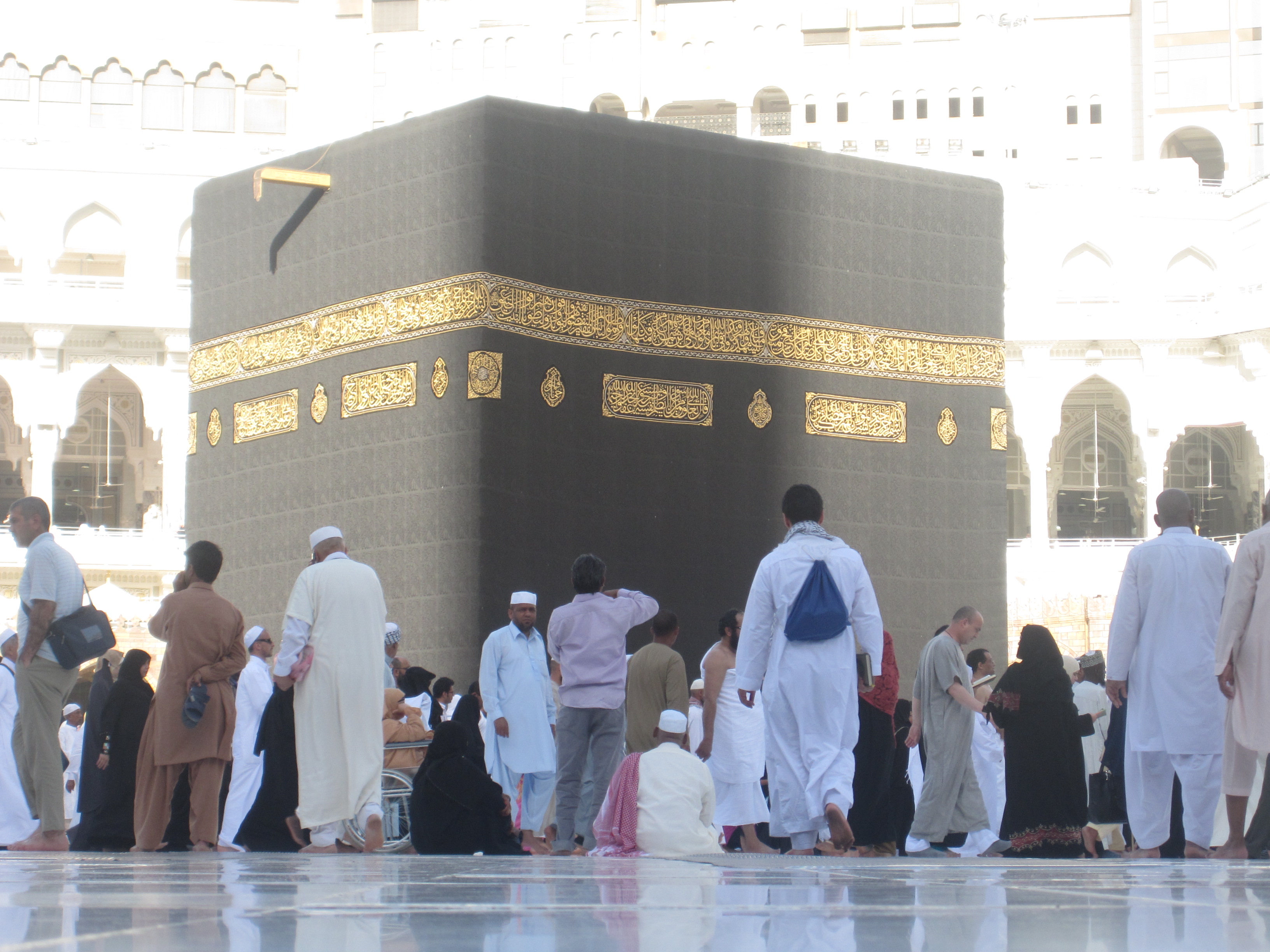 The Kaaba, draped in black silk and gold embroidery, at night.