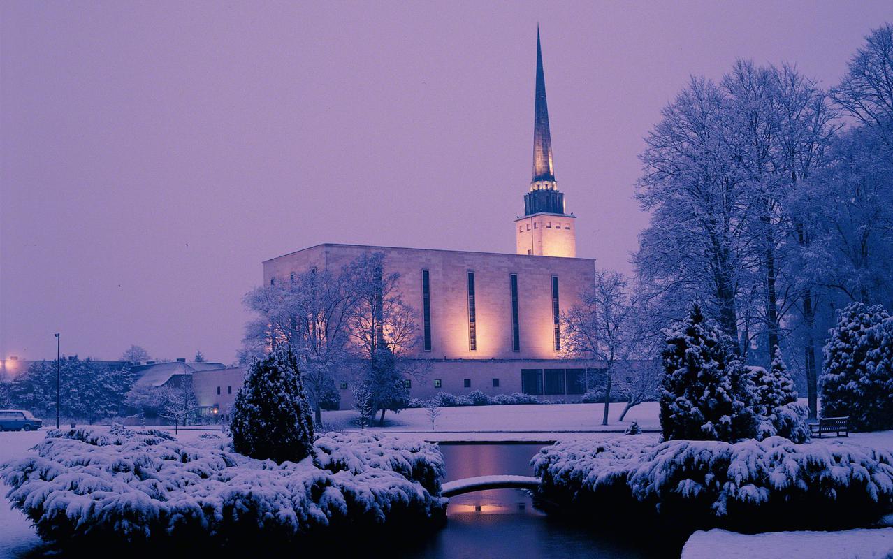 The London England Temple surrounded by lush greenery.