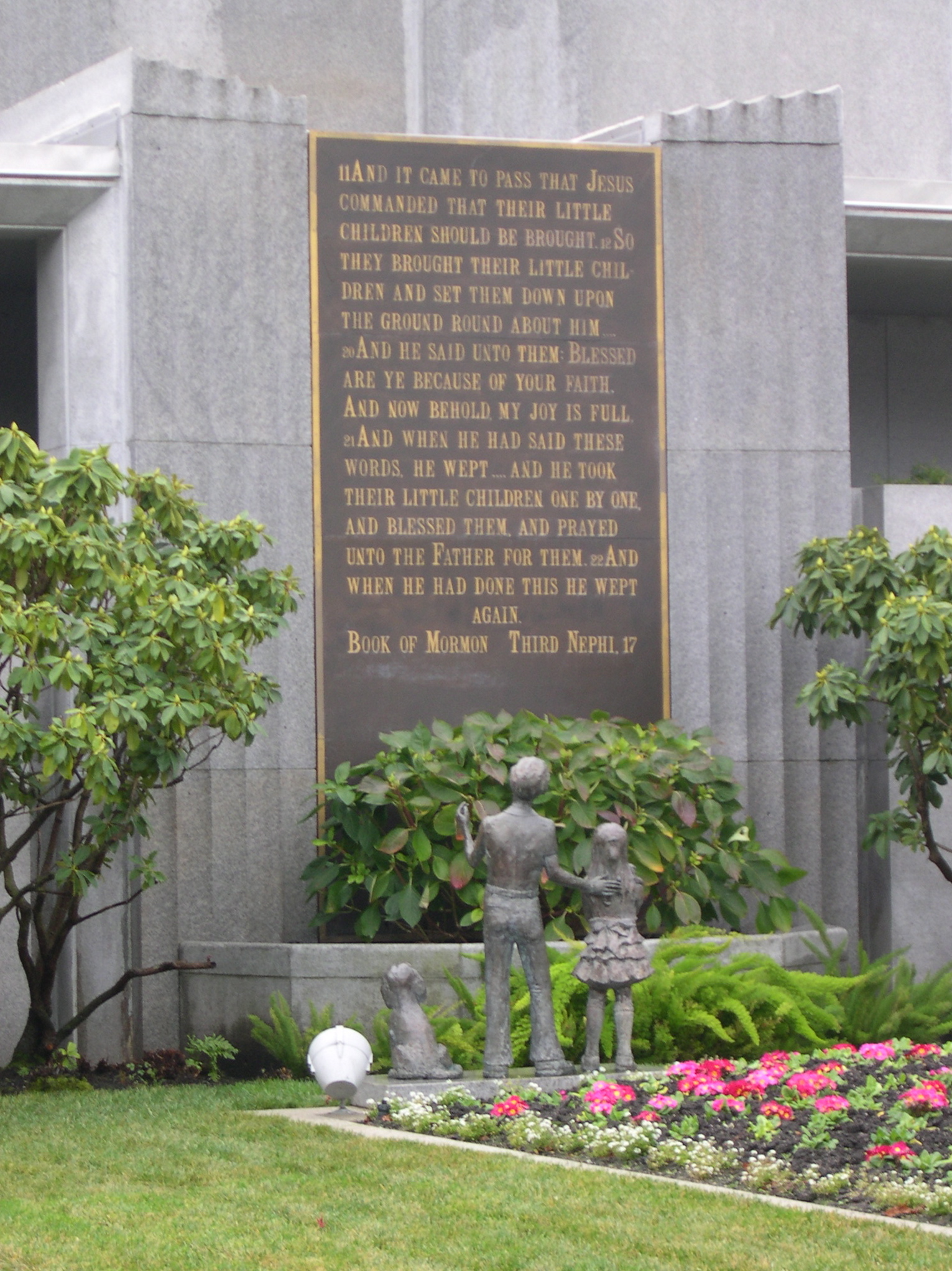 A close-up of the sculpted frieze on the temple's exterior, depicting Jesus Christ with children.