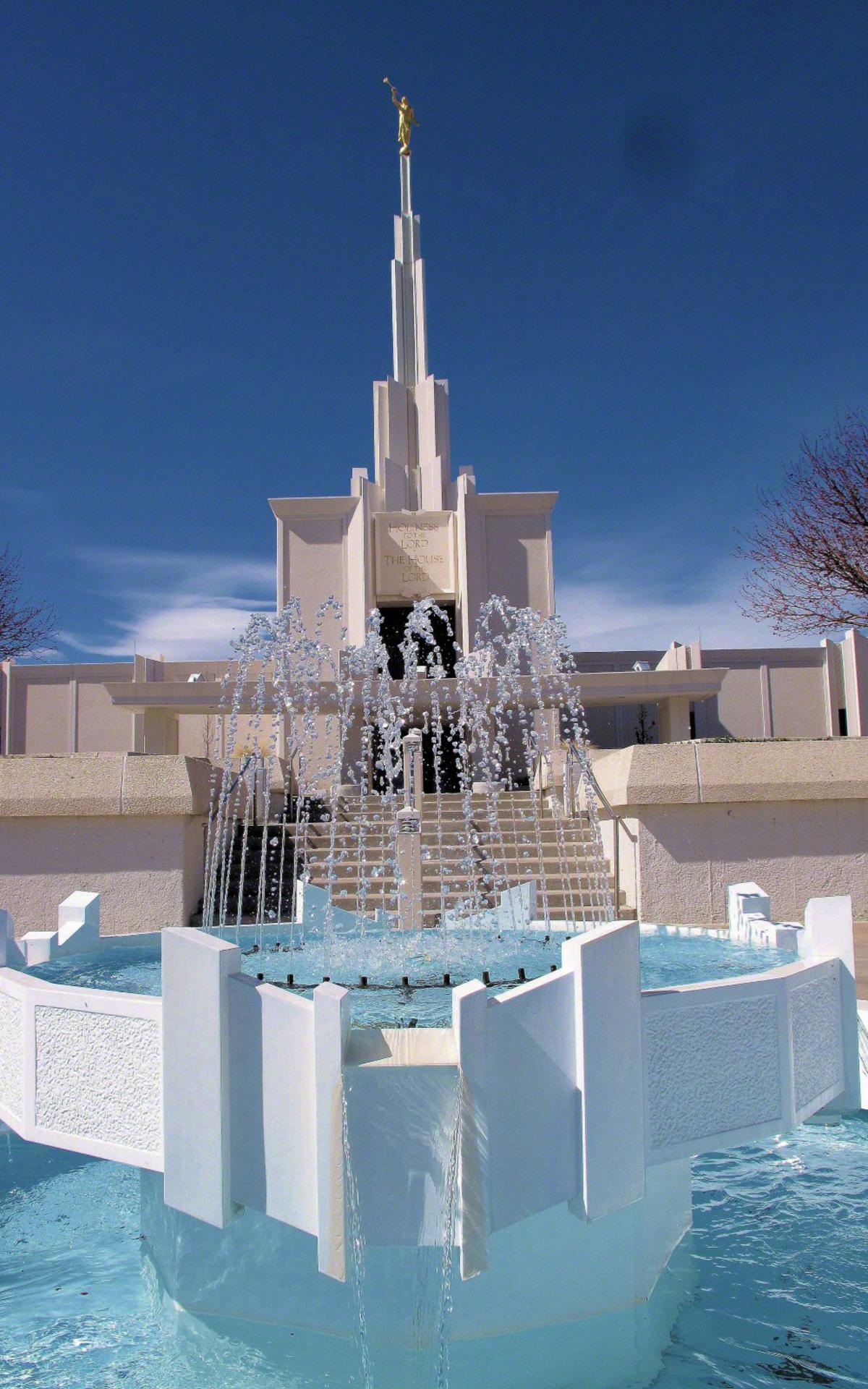 A wide view of the temple from the landscaped grounds, showing its hilltop setting.