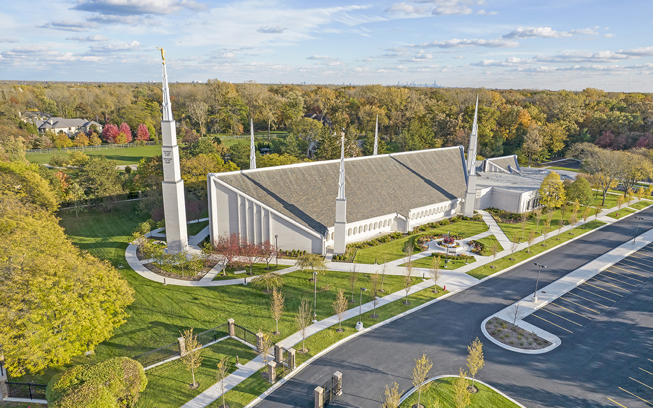 The temple entrance surrounded by mature trees and seasonal plantings.
