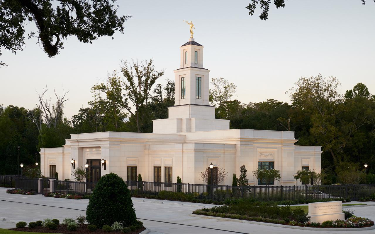 The beautifully illuminated Baton Rouge Louisiana Temple at dusk, showcasing its classical limestone exterior.