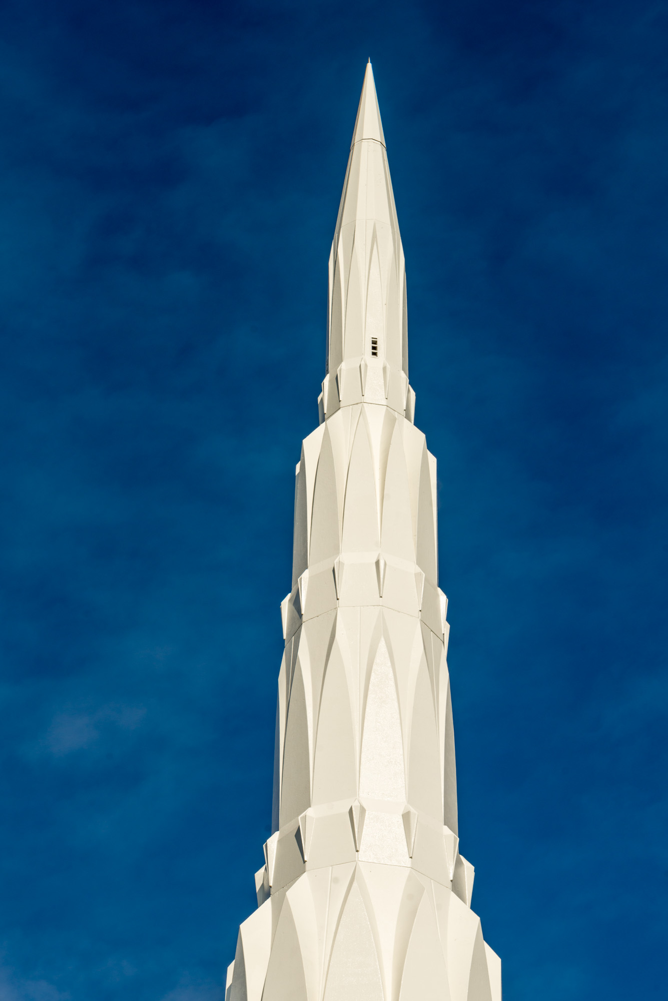 Close-up of a temple spire against a deep blue sky
