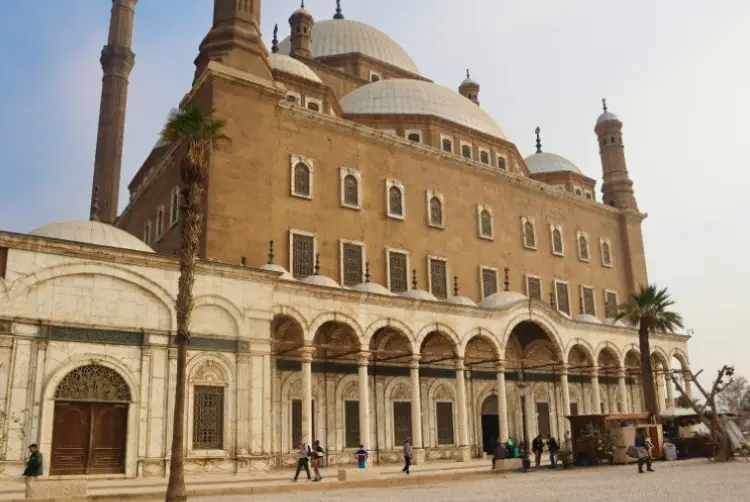 מצודת קהיר, כפי שנראית מהקרקע, מבט למעלה אל המבנה הגבוה עם מגדלים גבוהים וקשתות עשויות אבן חומה ואדומה. חלונות רבים מקיפים את חזית המצודה הנראית לעין, במבנה רשת.